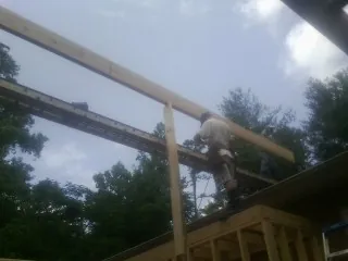 Carpenter setting a ridge beam over a new addition frame — Ice Dam Removal by Roofing Brothers in Rio Grande