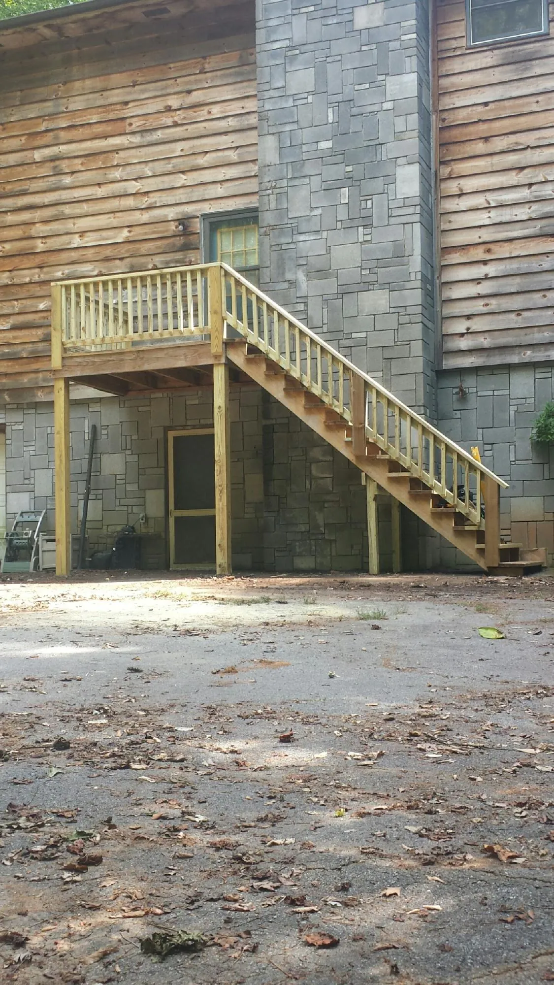 New pressure treated deck and stair landing on a log home in Rio Grande