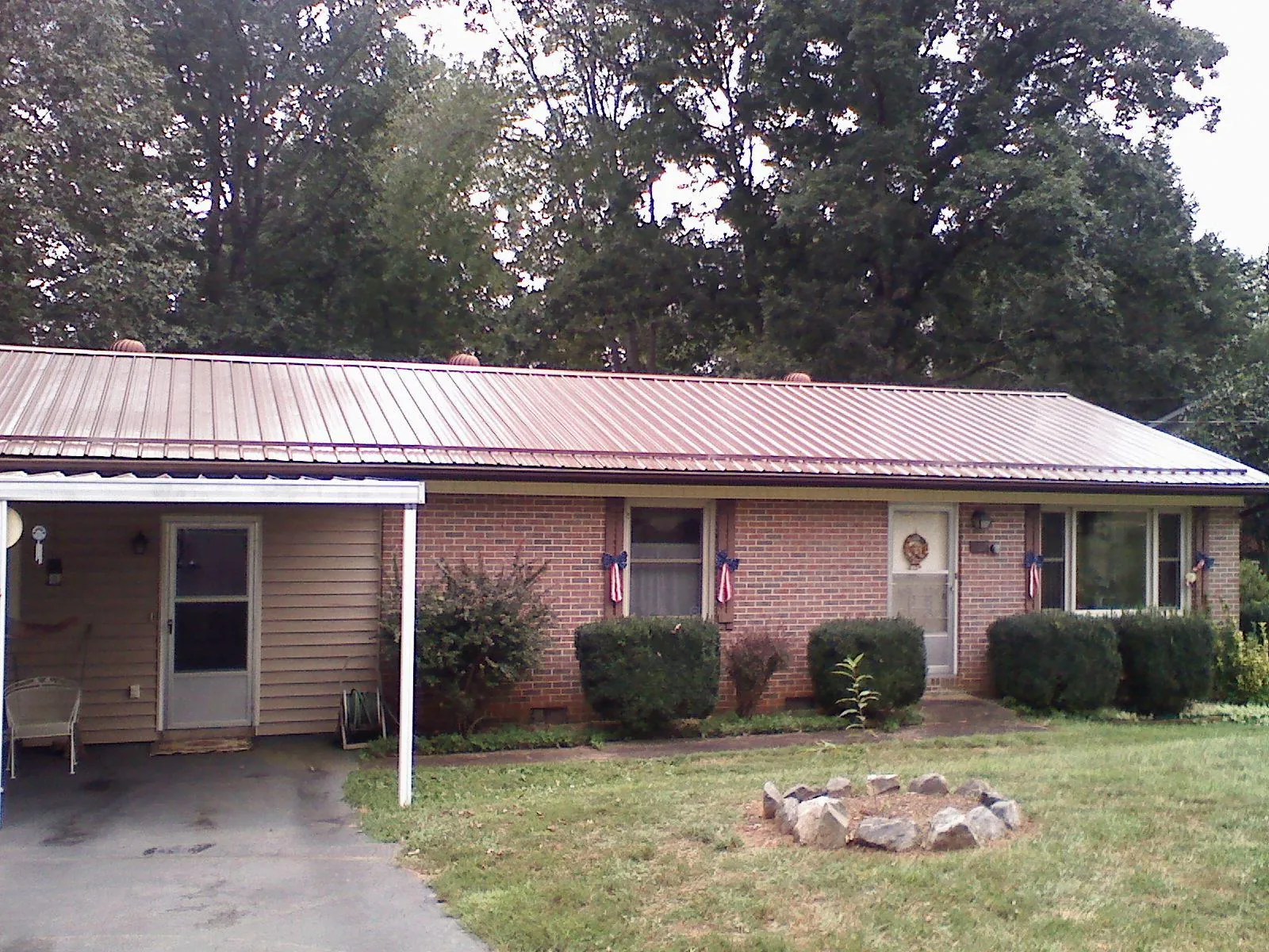 Bronze metal roof and carport on a brick ranch home — Roof Repair work by our crew in Rio Grande